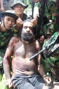 Indonesian soliders pose for a 'trophy photo' after killing West Papuan tribal elder Yustinus Murib