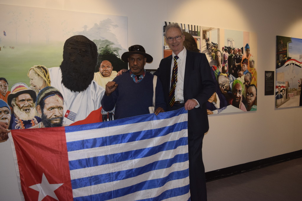 West Papuan Independence Leader, Benny Wenda meeting UK artist Paul Piercy in front of Paul's painting of West Papuan political prisoner Filep Karma 